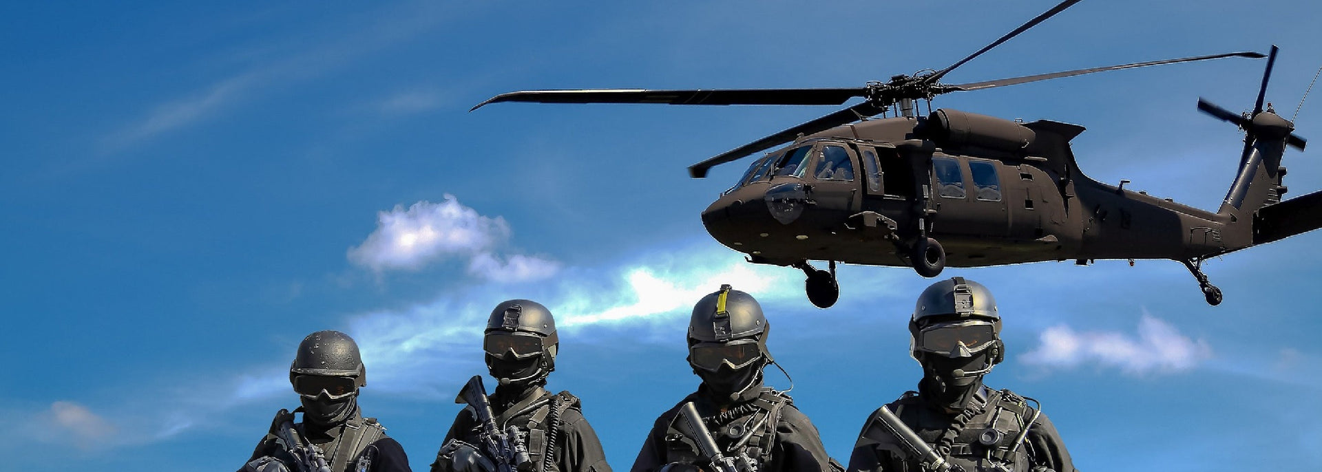 Military helicopter with soldiers below on ground